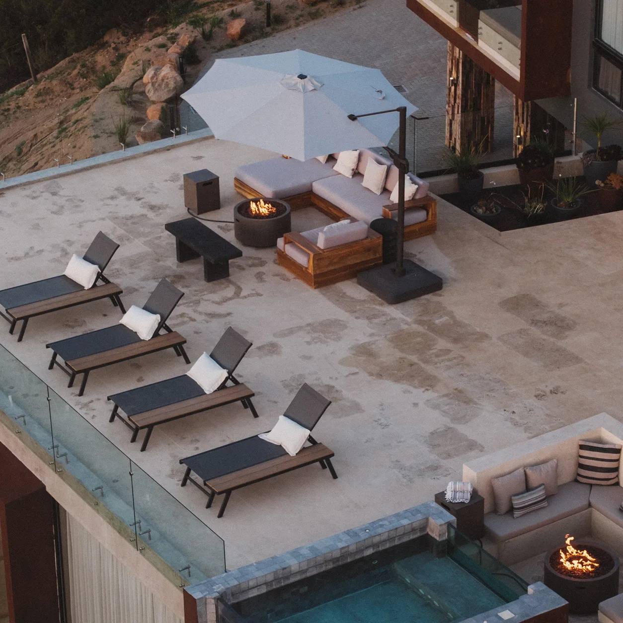Aerial view of Kasa Kefi's rooftop terrace with lounge chairs, fire pit, and plunge pool