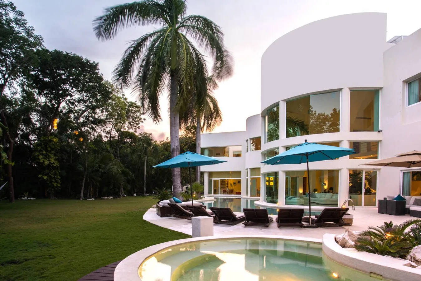 Poolside umbrellas and loungers beneath the palms at Villa Aqua